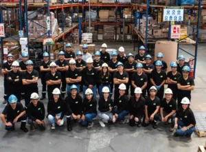 Equipo de colaboradores de EFC posando en almacén industrial, celebrando 55 años de trayectoria en abastecimiento industrial en Perú.